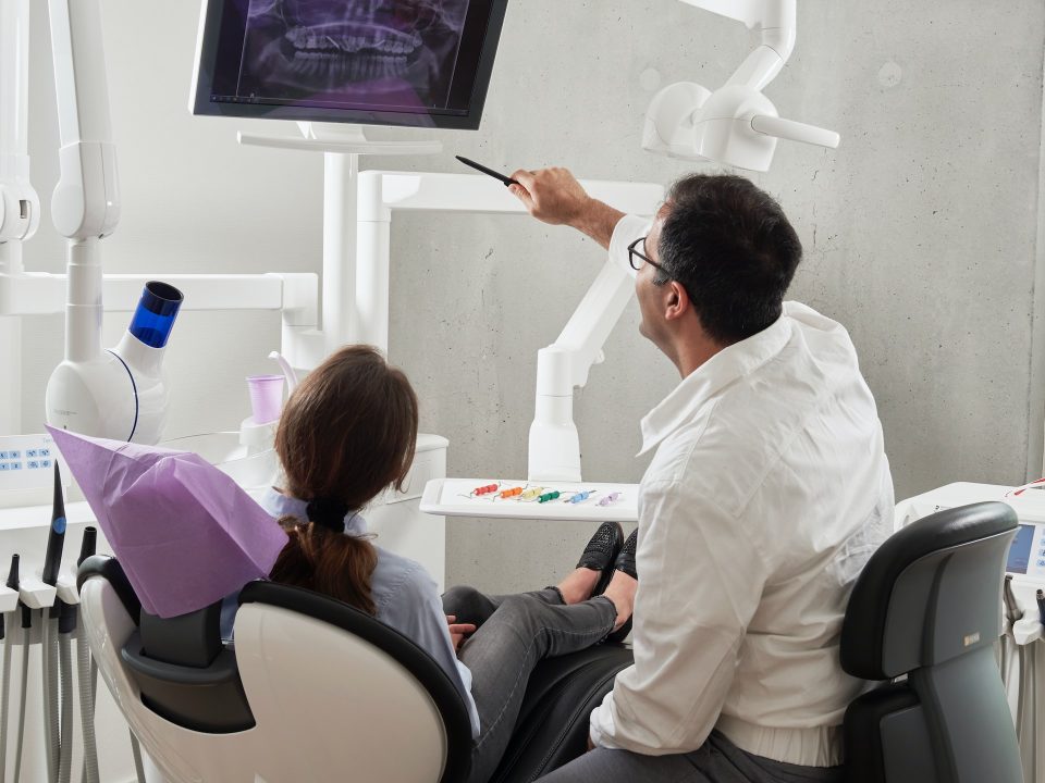 doctor showing xray images and detailing about complex dental implants treatment| scientific dental clinic