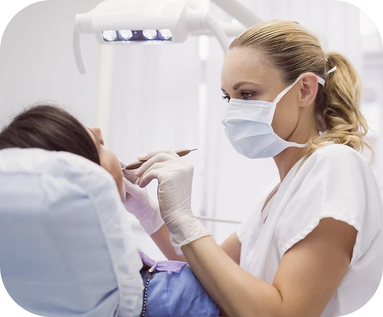 Dentist examining patient’s teeth in dental clinic
