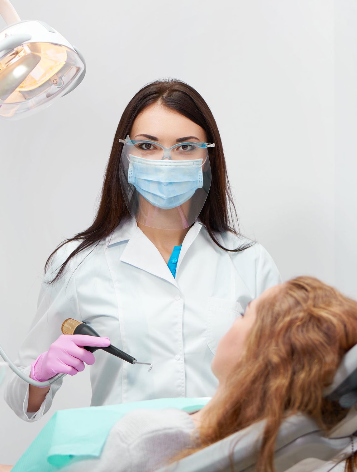 image of a dentist treating a patient in Scientific dental clinic