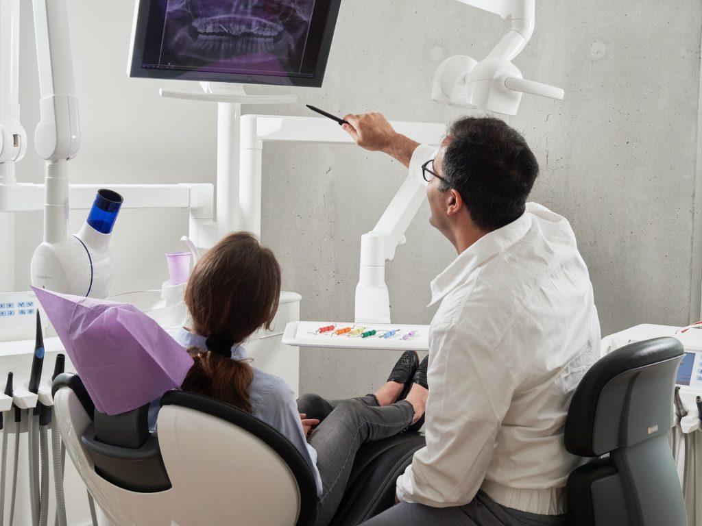 a doctor showing dental xray to a patient | Scientific dental clinic, kochi